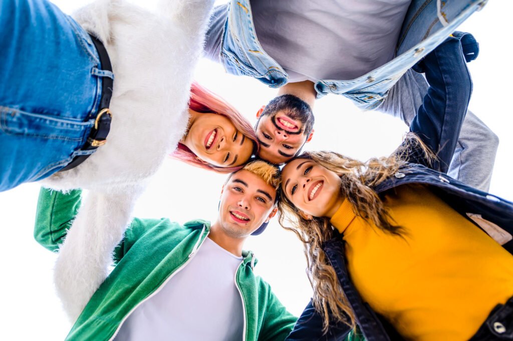 Group of young friends joyfully embracing each other