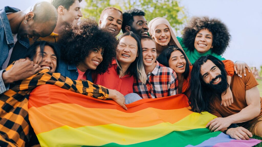 People holding a rainbow flag, showing support for LGBTQ+ rights and equality.