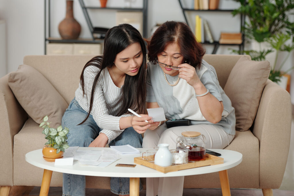 Mother and daughter sitting together, reviewing finances
