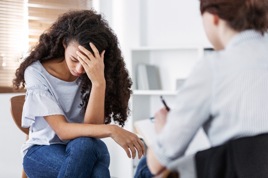 PTSD sufferer with head in hands talking to doctor